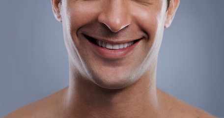 Image showing Man, face and smile with skincare and lips with hygiene, jawline and satisfaction with treatment closeup. Grooming, confidence and mouth with young male model in studio background for cosmetic