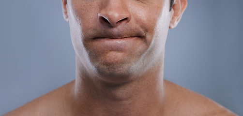 Image showing Man, mouth and face with clean shave, facial hygiene and upset with cosmetic treatment closeup. Grooming, mockup space and skincare with young male model in studio background with epilation