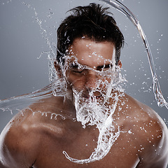Image showing Water drops, splash and man wash face for bathroom routine, self care or beauty treatment. Studio, bathing and male model with facial cleanse for hygiene, grooming and clear skin on grey background