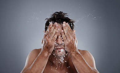 Image showing Water drops, splash and man clean face for bathroom routine, dermatology cleanse or beauty treatment. Studio, refresh and model facial washing, hygiene and grooming for clear skin on grey background