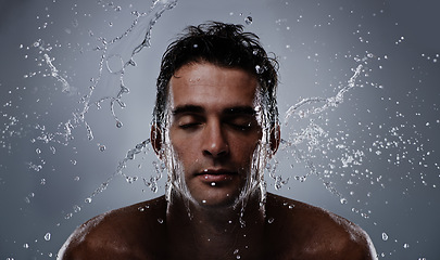 Image showing Water splash, liquid and man wash face for bathroom routine, self care or beauty treatment. Eye closed, bathing and model headshot with hygiene, grooming and facial cleanse on dark grey background