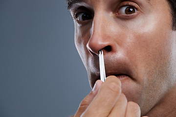 Image showing Man, nose and hair with tweezers in studio on grey background for self care, wellness or dermatology. Male person, face and grooming for cosmetic beauty or healthy cleaning, wellbeing or mockup space