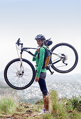 Image showing Woman, holding mountain bike and smile in portrait with pride, fitness and view of cityscape from hill. Girl, person and happy with bicycle on adventure, training or exercise for wellness in nature