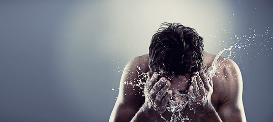 Image showing Man, water and splash face in studio for healthy cleaning or skincare hygiene, treatment or grey background. Male person, hands and washing routine for bathroom self care, wellness or mockup space