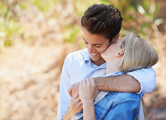 Image showing Happy couple, kiss and hug in nature for bonding, love or support in relax for outdoor affection. Face of young woman and man with smile for embrace, comfort or romance in forest or woods together