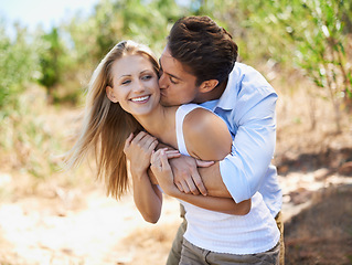 Image showing Mwah. Couple, face and happy with kiss in nature or relationship for holiday, vacation or travel. Romance, man and woman with smile outdoor in forest with embrace for bonding, love or relax in woods.