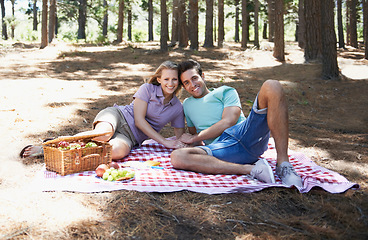 Image showing Happy couple, picnic portrait and nature with love, romantic celebration and summer date for valentines day. Young people with food, fruits and relax on blanket in woods or forest for anniversary