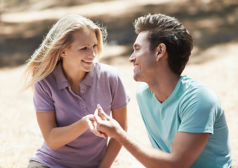 Image showing Happy couple, engagement and ring in nature for love, support or commitment in forest or outdoor romance. Young man and woman or lovers smile in embrace or affection for marriage or wedding proposal