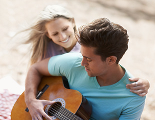 Image showing Couple, picnic and playing guitar for romance, love or song in outdoor bonding, fun or relaxing together in nature. Man and woman smile with instrument for acoustic sound, strumming or music outside