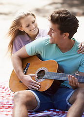 Image showing Happy couple, picnic and playing guitar for romance, love or music in outdoor bonding, fun or relaxing together in nature. Man and woman smile with instrument for acoustic sound or songs outside