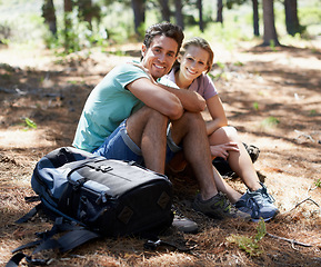 Image showing Couple, hiking break and portrait in forest for outdoor travel, adventure and wellness journey in nature. Happy man and woman relax on ground with backpack for trekking destination, health or fitness