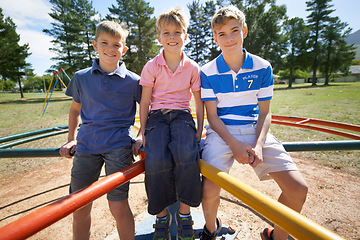 Image showing Friends, brothers and smiling on playground in portrait, children and play on merry go round at park. Happy siblings, carousel and bonding on outdoor adventure, love and active on vacation or holiday