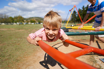 Image showing Child, boy and fun on playground in portrait, smile and outdoor adventure on merry go round at park. Happy male person, carousel and energy on obstacle course, kid and playing on vacation or holiday