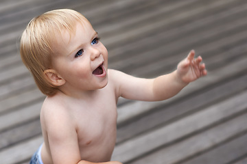 Image showing Baby, happy on floor outdoor for development with relax, curiosity and early childhood in backyard of home. Toddler, child and crawling on ground for wellness, milestone or exploring with playing