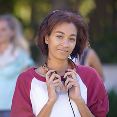 Image showing Young woman, headphones and portrait on campus, happy and nature with scholarship at college. Student, smile and face by audio electronics, music and university outdoor for streaming podcast at park