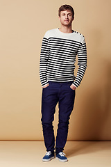 Image showing Pride, fashion and portrait of man on beige background in trendy, stylish and casual clothes. Happy, attractive and person with stripe style for positive attitude, confidence and smile in studio