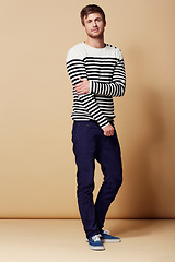 Image showing Fashion, confidence and portrait of man on beige background in trendy, stylish and casual clothes. Happy, hipster and person with stripe style for positive attitude, pride and smile in studio