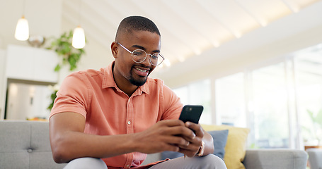 Image showing Happy, typing and a black man with a phone on the sofa for social media, connection or communication. Smile, relax and an African person with a mobile for an app, email or notification in a house