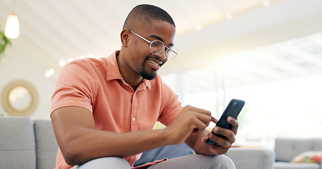 Image showing Happy, typing and a black man with a phone on the sofa for social media, connection or communication. Smile, relax and an African person with a mobile for an app, email or notification in a house