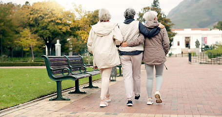 Image showing Senior friends, talking and walking together on an outdoor path to relax in nature with elderly women in retirement. Happy, people pointing and conversation in the park or woods in autumn or winter