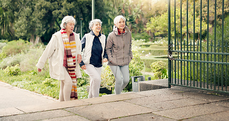 Image showing Senior friends, walking and talking together on an outdoor path to relax in nature with elderly women in retirement. People, happy conversation and healthy exercise in the park in autumn or winter