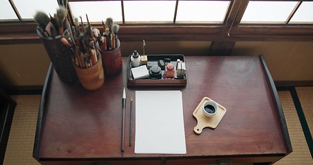 Image showing Art, paint brush and painting tool for painter, calligraphy and drawing at a desk for creative work. Sketch paper, Japanese sumi and home studio with ink pot and document for creativity above