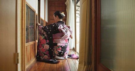 Image showing Open door, Japanese woman and culture with kimono, respect and relax in traditional accommodation. Morning, home and kneel at a window with zen, calm and ancient architecture with antique dress