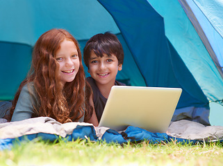 Image showing Children, portrait and happy with laptop for camping in tent, social media or online movie with vacation in nature. Family, face and siblings or smile outdoor on grass for trip, relax and holiday fun