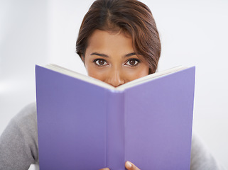 Image showing Woman, student or portrait with book in studio, reading or closeup for research of assignment. Young person, indian or face in notebook for test, studies or positive for education by white background