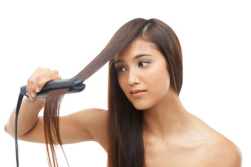 Image showing Hair care, straightener and young female model in studio for cosmetic, salon and beauty treatment. Flat iron tool, confident and woman with healthy and shiny hairstyle routine by white background.