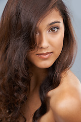 Image showing Portrait, care and beauty of woman with curly hair in studio isolated on a grey background. Face, aesthetic and hairstyle of model in makeup cosmetics, hairdresser and salon treatment for skin glow