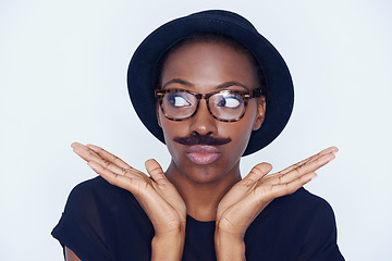 Image showing Funny, woman and mustache on face in studio with hipster fashion and creative model in background or mockup. Silly, nerd and African person with goofy style and joke with trendy hat or unique outfit