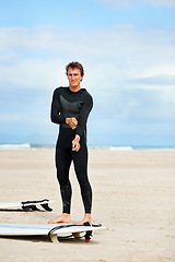 Image showing Surfer, man and portrait with surfboard on beach with wetsuit, blue sky or dressing with mock up space. Extreme sports, athlete and person by ocean for training, surfing workout or holiday adventure