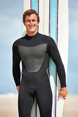 Image showing Beach, portrait or happy man with surfboard for exercise, fitness for body health or summer outdoor. Surfer, wetsuit or smile of person by ocean for water sports, travel or holiday vacation in Hawaii