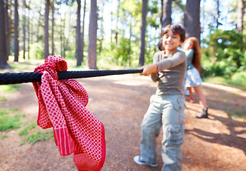 Image showing Kids, game and tug of war in forest at summer camp and holiday with travel and energy outdoor. Children with rope, adventure and team building with fun contest, playful and young friends in a park