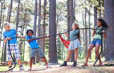 Image showing Kids, rope and tug of war for play adventure, challenge and strength game in woods with summer camping. Children, diversity and competitive in forest environment and teamwork in power match by trees