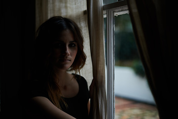 Image showing Woman, portrait and relax by window at night in dark room in stress, anxiety or mental health and lonely at home. Young female person sitting by glass at house with insomnia in neighborhood apartment