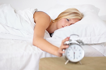 Image showing Tired, woman and wake up with alarm in morning and sleeping on bed in home with stress or fatigue. Press, snooze and girl frustrated with clock and time to start day in bedroom and apartment