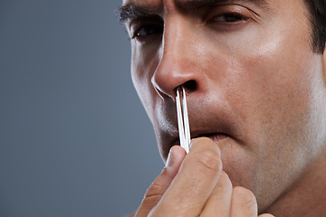 Image showing Nose, hair removal and portrait of man closeup with pain from cleaning with tweezers in studio background. Beauty, epilation and person with grooming routine and treatment for self care with tools