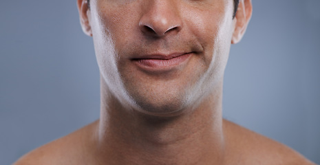 Image showing Man, mouth and smirk with face and lips for hygiene, jawline, and unhappy for treatment closeup. Grooming, mockup space and skincare with male model in studio background for clean cosmetics zoom