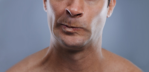Image showing Man, mouth and angry with shave, face and hygiene with skincare, upset, and frustrated with treatment closeup. Grooming, mockup space and moody with male model in studio background with cosmetics