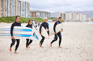 Image showing Friends, surf and ocean with walking, fitness and exercise by the sea and beach. Group, outdoor and surfer with travel, training and water on vacation and holiday in Miami with freedom on trip