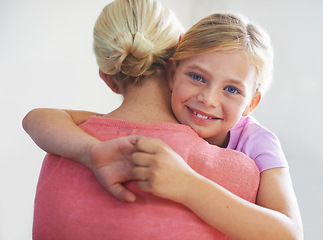 Image showing Mother, girl and hug in portrait, bonding and love in childhood by single parent in studio. Daughter, mommy and caring together on white background, embracing and security or enjoying connection