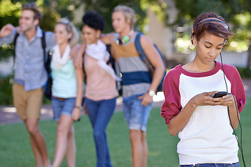 Image showing Young woman, headphones and cellphone on campus, typing and break with wellness at college. Student, smile and smartphone on social media on internet, technology and university outdoor for connection