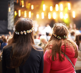 Image showing Women, friends and music festival in audience at outdoor concert, listening to live band. Female people, stage and watching entertainment in park for fun holiday weekend rave, vacation at party event