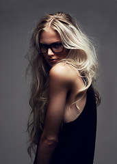 Image showing Portrait, woman and glasses in studio with fashion, style and trendy aesthetic with positive by gray background. Model, pride and eyecare on face with attitude, blonde and cool in sunglasses