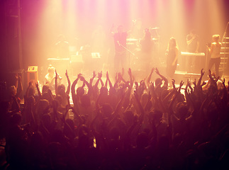 Image showing Concert, audience and rock music with hands up from people at dj, band and festival event at a stage with lights. Show, dance and party with excited crowd in rave, techno and entertainment at venue