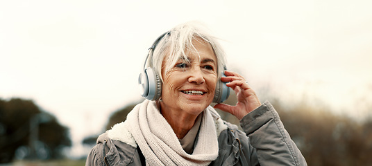 Image showing Old woman, headphones and listening to music outdoor, walking and wellness with audio streaming and energy. Podcast, radio and sound with female person on city bridge, exercise and travel with tech