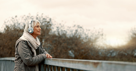 Image showing Bridge, senior woman and headphones with music and thinking outdoor with view. Elderly female person, web radio and mockup space feeling relax in retirement with audio and freedom on calm holiday