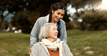 Image showing Senior woman, talking and outdoor with caregiver, nurse or healthcare service for person with a disability and wheelchair. Happy, face and elderly lady in park with care and support in retirement